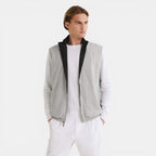 Man wearing a gray cardigan with black trim over a white shirt and pants on a white background