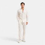 Man wearing a white linen suit on a white background