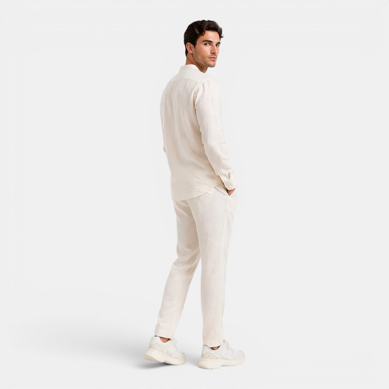 Man wearing a white outfit on a plain background