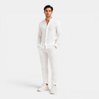 Man wearing a white outfit on a plain background
