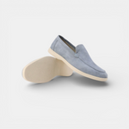 Pair of light blue loafers on a white background