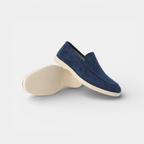 Blue suede loafer shoes on a light gray background