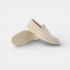 Pair of beige loafers on a light gray background