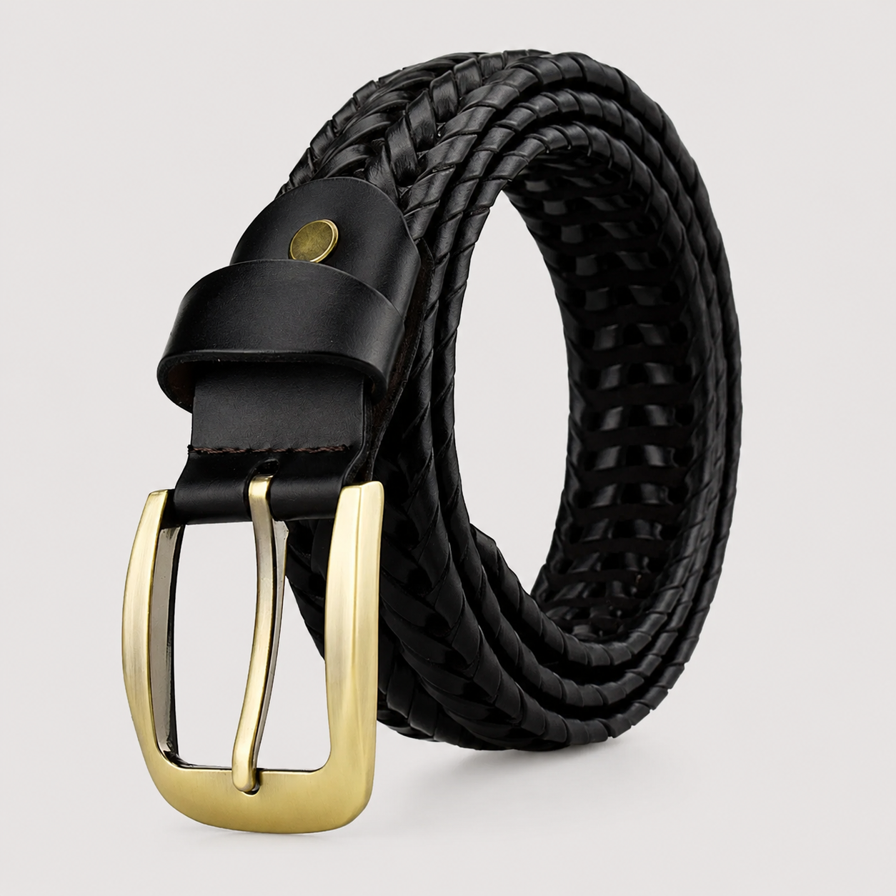 A black braided leather belt with a polished gold-tone buckle, coiled on a light gray background.