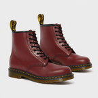A pair of classic Dr. Martens 1666 8-eyelet lace-up boots in burgundy leather, shown on a light gray background.