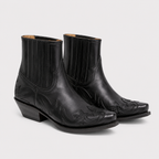 A pair of black leather ankle boots with western-style stitching, embossed floral details on the toes, and elastic side panels, shown against a light gray background.