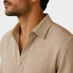 Close-up of a beige shirt worn by a person on a light gray background