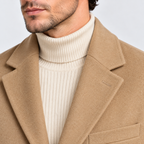 Close-up of men's camel overcoat notched lapel and beige turtleneck sweater