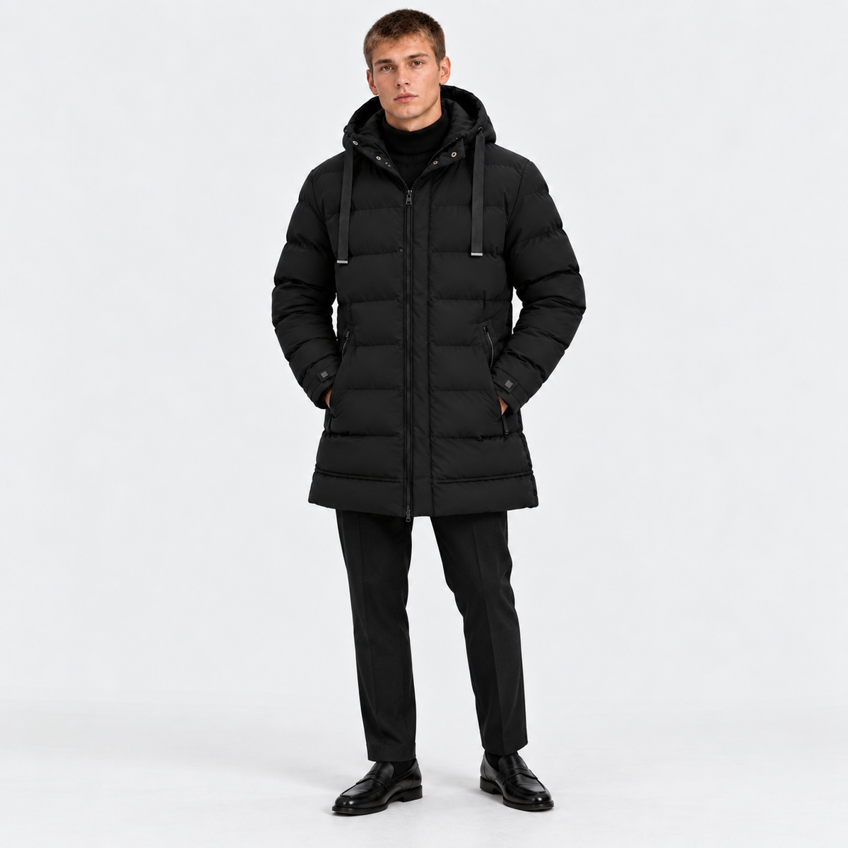 Man wearing a black hooded puffer jacket with black pants