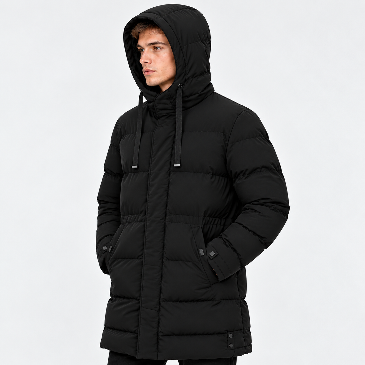 Side view of a man wearing a black hooded puffer jacket with quilted panels