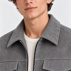 Close-up of men's gray jacket with pointed collar, front zipper, and textured fabric