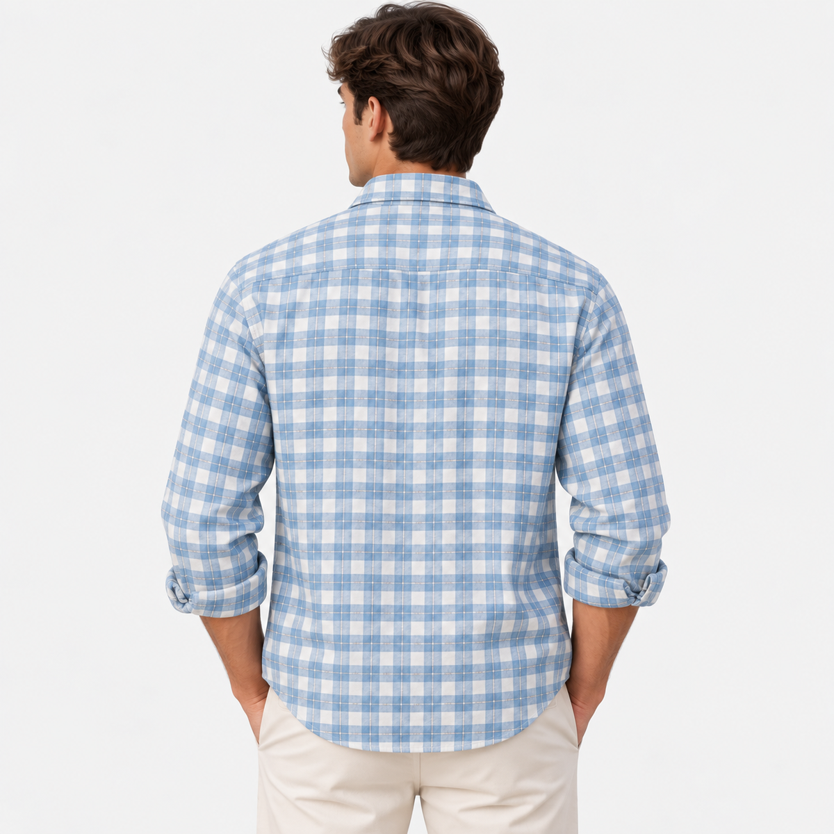 A man viewed from the back wearing a light blue and white gingham plaid long-sleeve button-down shirt with cream pants, set against a plain white studio background.