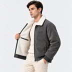 Side view of a man wearing a gray shearling collar jacket with white pants