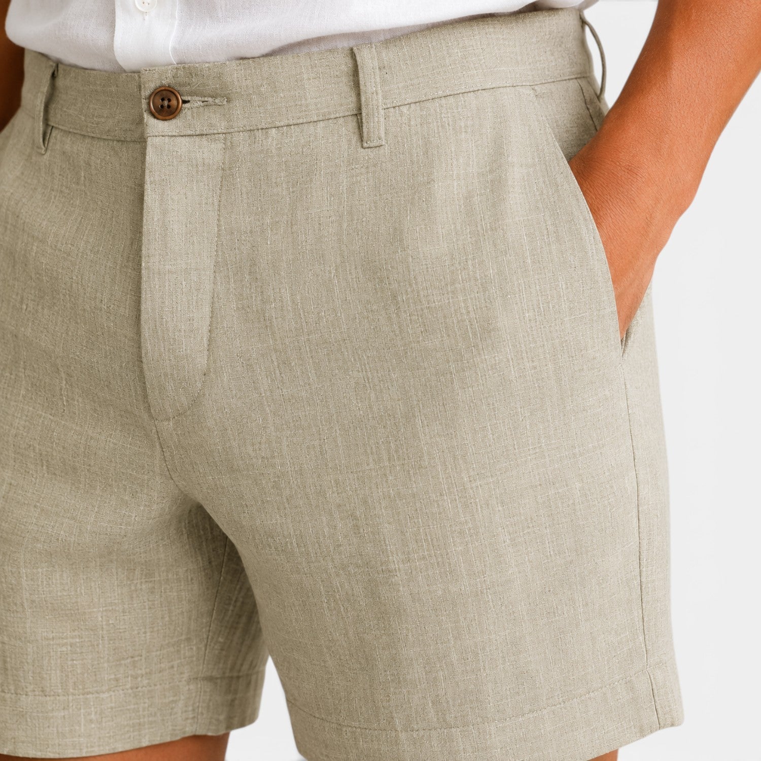 Beige shorts worn by a person on a white background