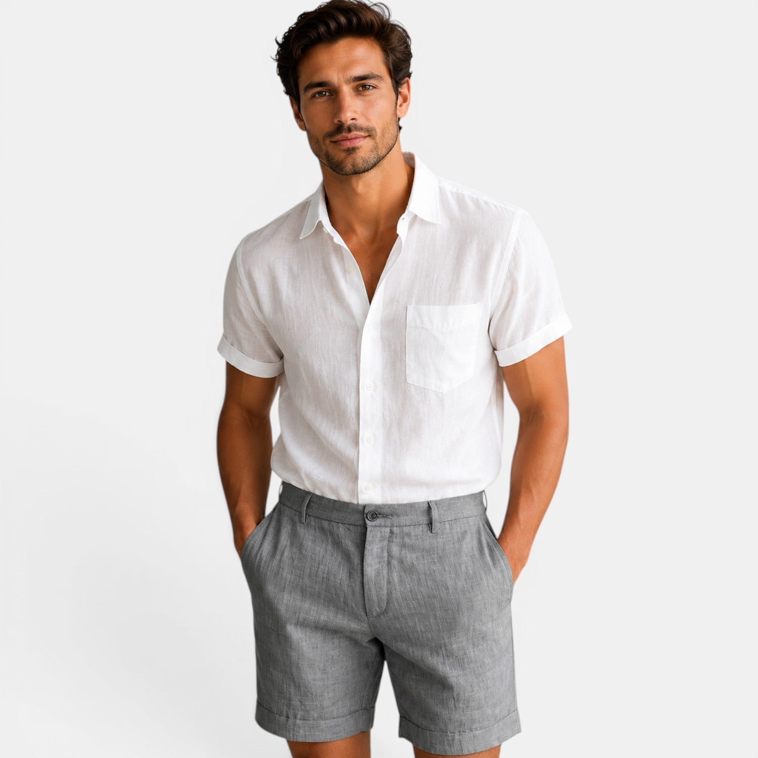 Man wearing a white shirt and gray shorts on a plain background