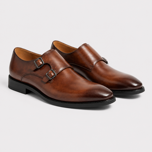A pair of men's brown leather double monk shoes with black soles, displayed on a light gray background.