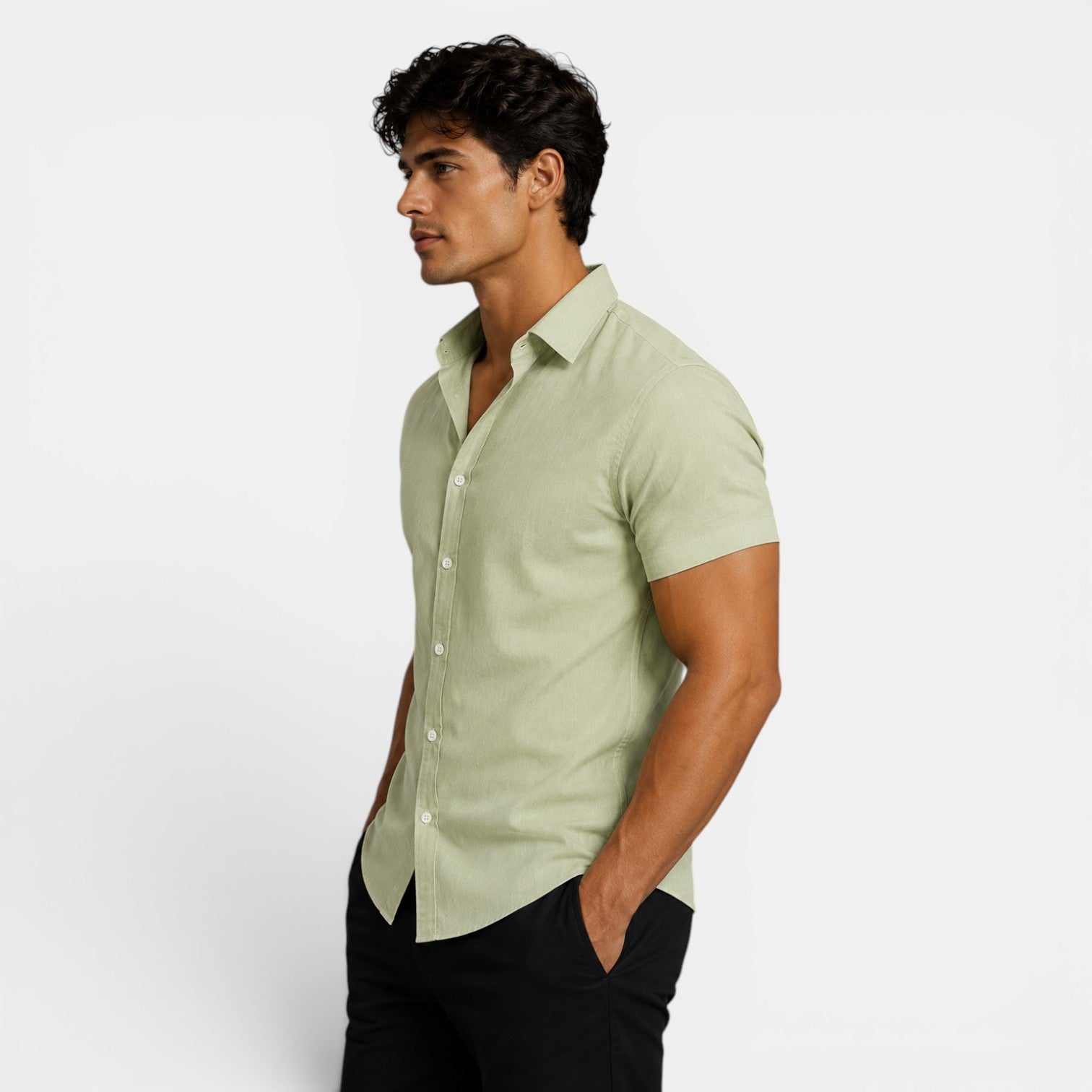 Man wearing a light green shirt and black pants on a white background