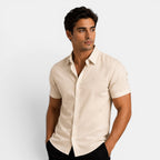 Man wearing a beige short-sleeve shirt against a light gray background