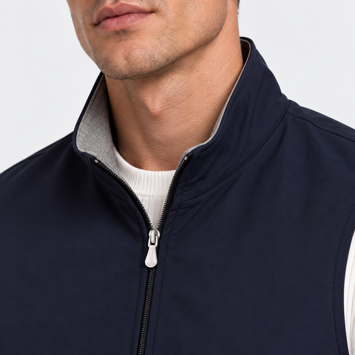 Close-up of men's navy blue vest with stand collar and zipper closure