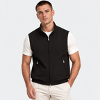 Man wearing a black sleeveless zip-up vest with white shirt and pants
