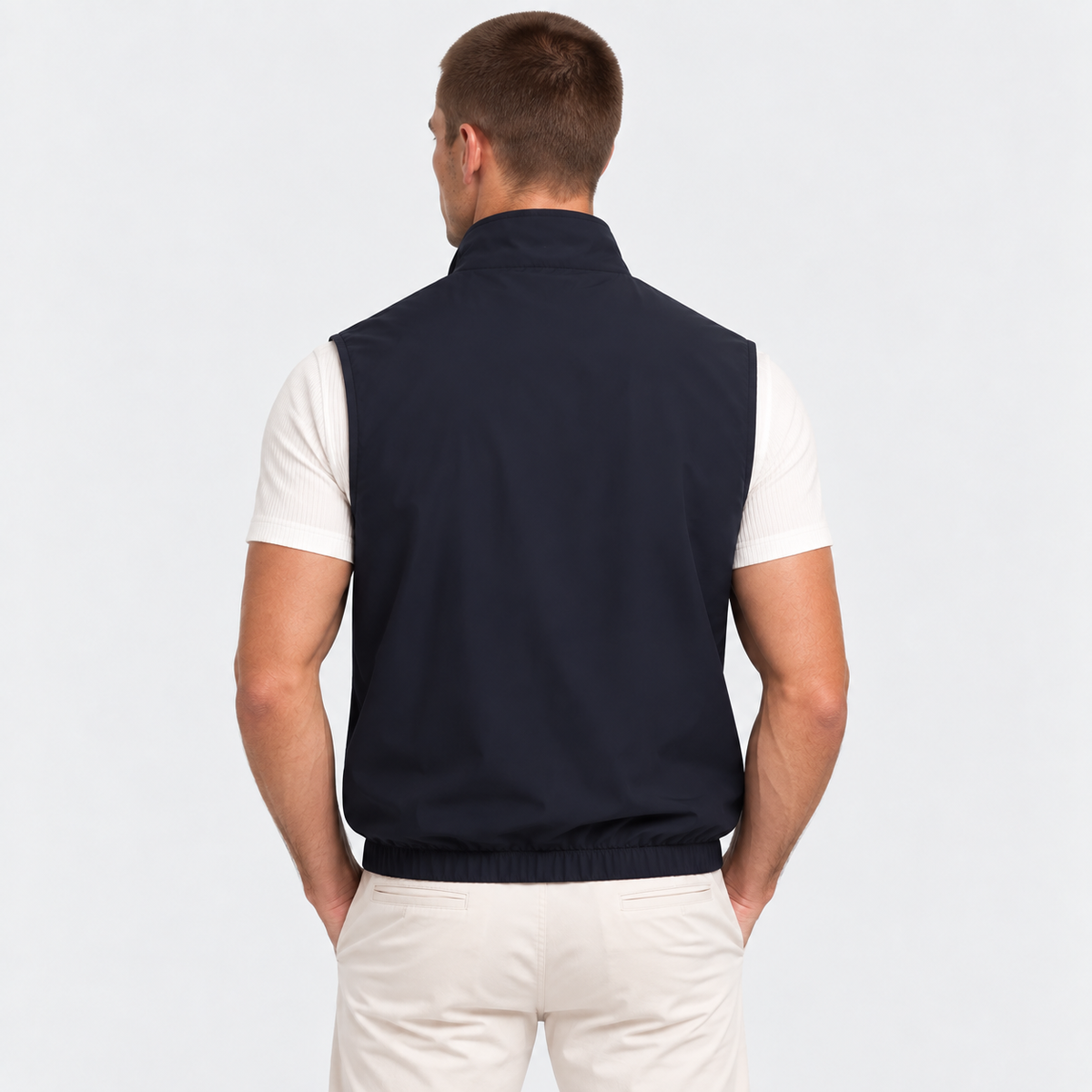 Back view of a man wearing a navy blue zip-up vest