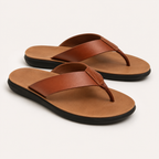A pair of brown leather thong sandals with tan footbeds and black soles, photographed on a clean off-white background.