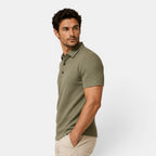 Man wearing a green polo shirt against a white background