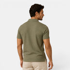 Man wearing a green patterned polo shirt on a white background