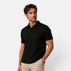 Man wearing a black polo shirt against a light gray background