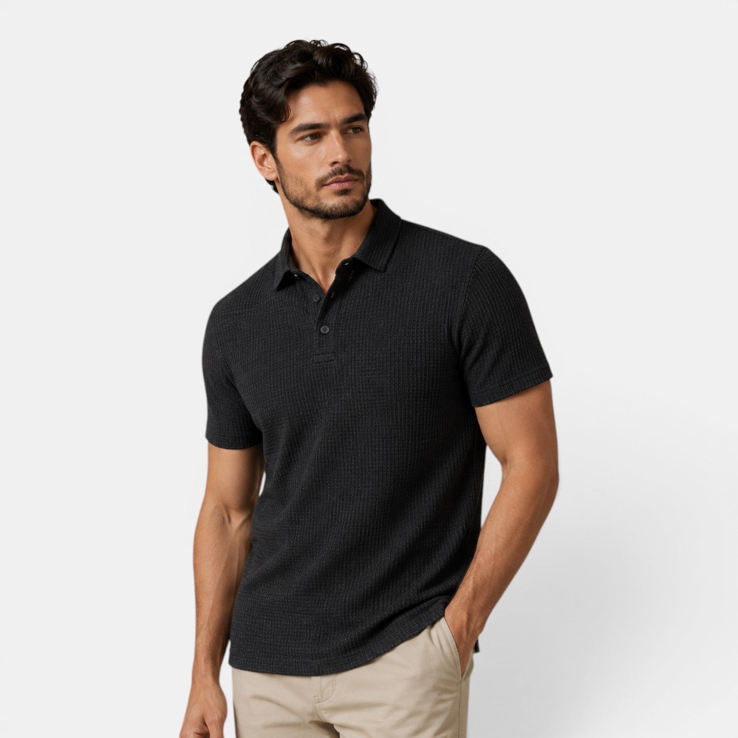 Man wearing a black textured polo shirt against a light gray background