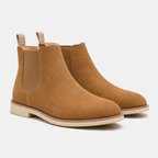A pair of tan suede Chelsea boots with elastic side panels and pull tabs, shown on a light gray background.