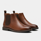 A pair of men's brown leather Chelsea boots with dark brown elastic side panels and pull tabs, shown on a light gray background.