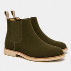 A pair of olive green suede Chelsea boots with elastic side panels and pull tabs, shown on a clean white background.