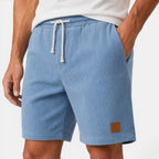 Blue shorts with a drawstring and brown label on a white background