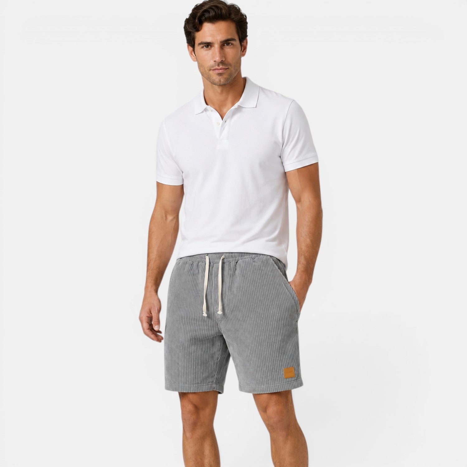 Man wearing a white polo shirt and gray shorts on a white background