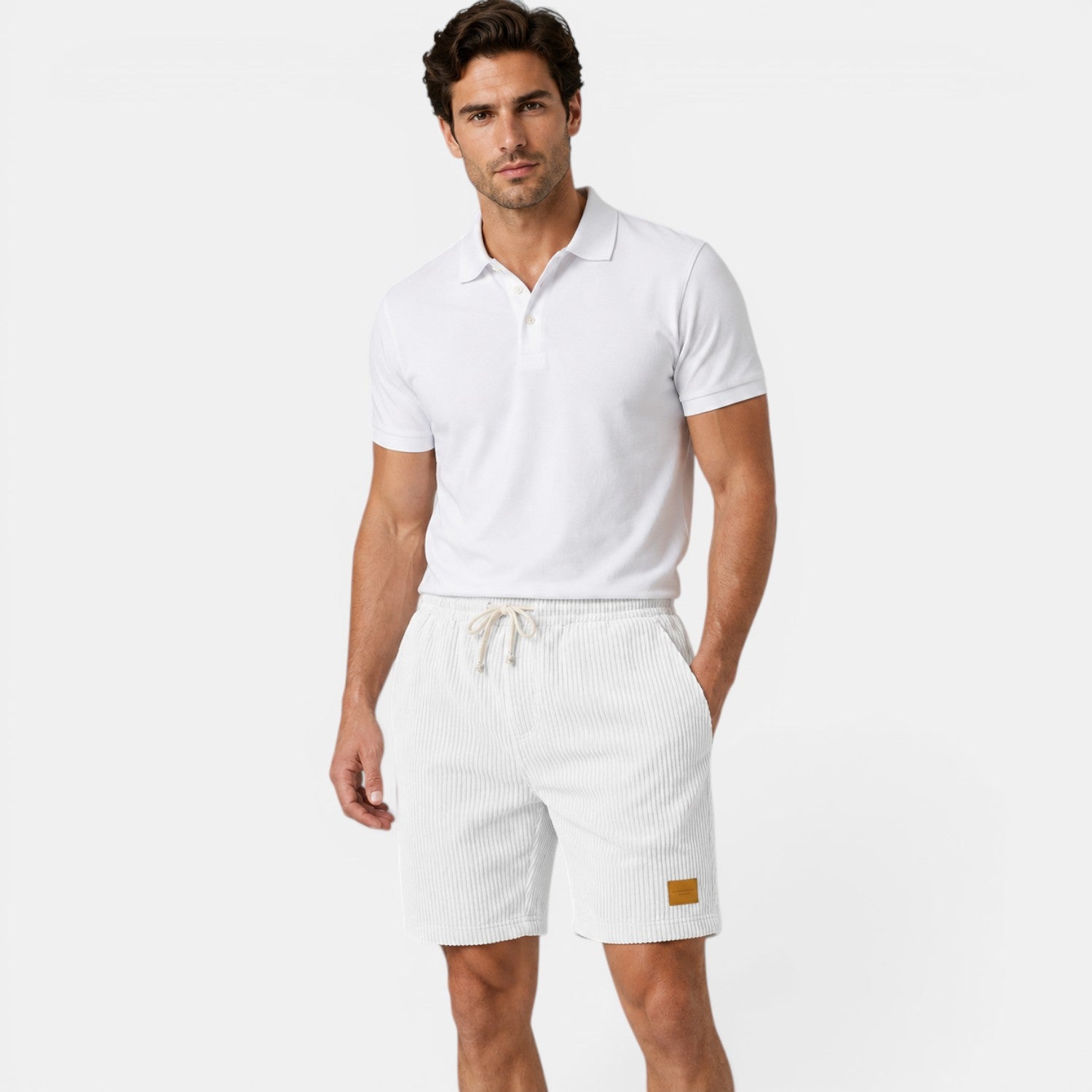 Man wearing a white polo shirt and shorts on a light gray background