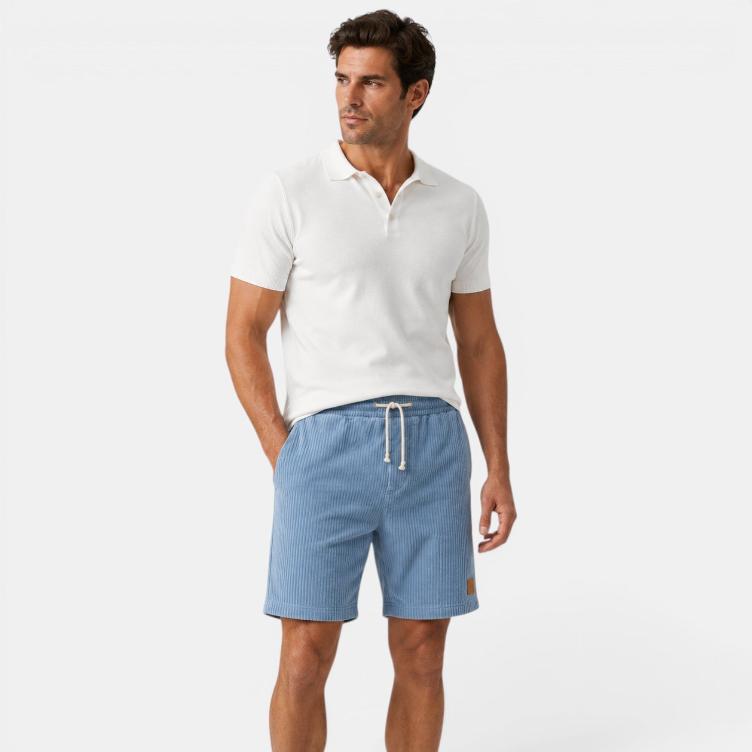 Man wearing a white polo shirt and blue shorts on a white background