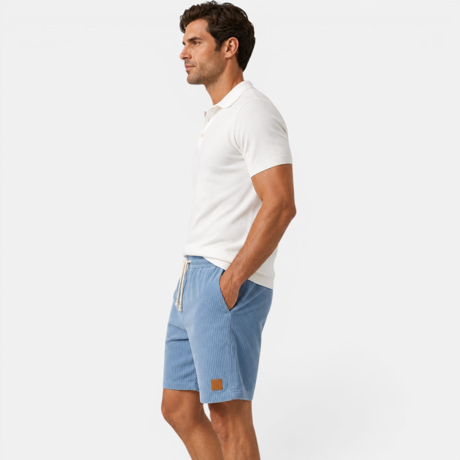 Man wearing a white polo shirt and blue shorts on a white background