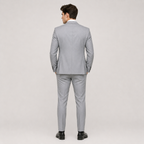 A man wearing a light gray two-piece suit, shown from the back, standing against a neutral light gray studio background.