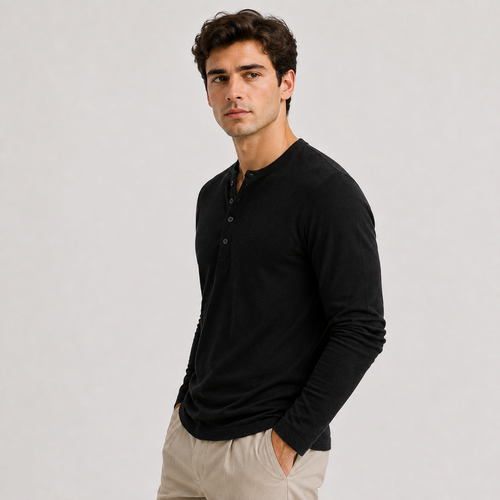 A man wearing a black long-sleeve henley shirt and beige trousers, standing against a light gray studio background.