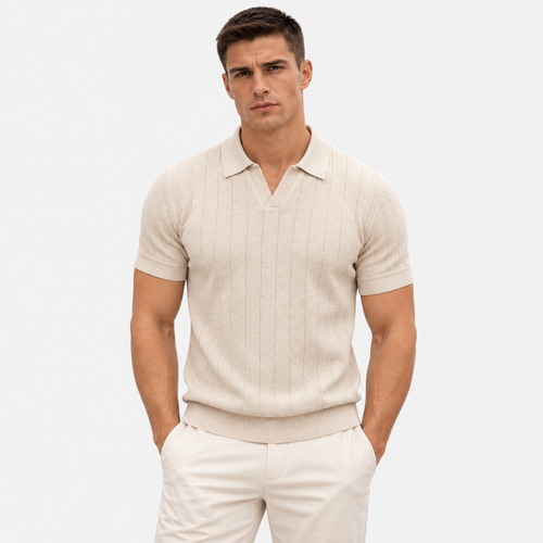 A man wearing a light beige ribbed knit short-sleeve polo shirt and cream trousers, standing against a plain light gray studio background.
