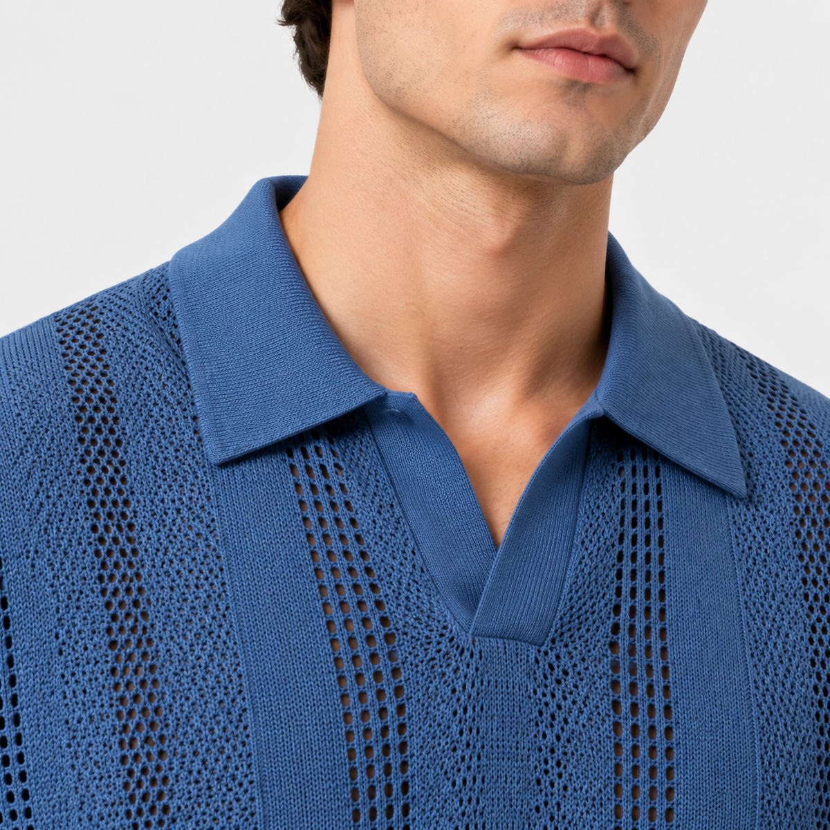 Close-up of a man wearing a textured blue knit polo shirt with a collar and openwork knit pattern, against a light gray background.