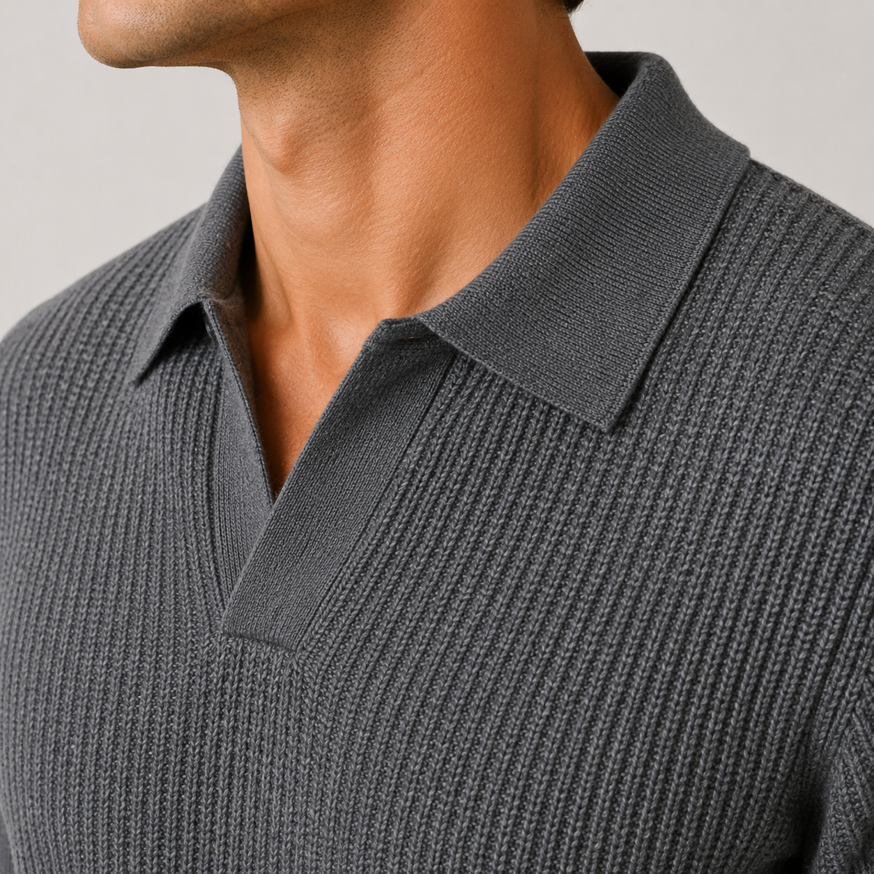 Close-up of a man wearing a dark gray ribbed knit polo shirt, showing the collar and textured fabric.