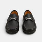 Pair of black leather loafers with silver buckles on a white background