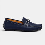 Navy blue loafer shoe with a silver buckle on a light gray background
