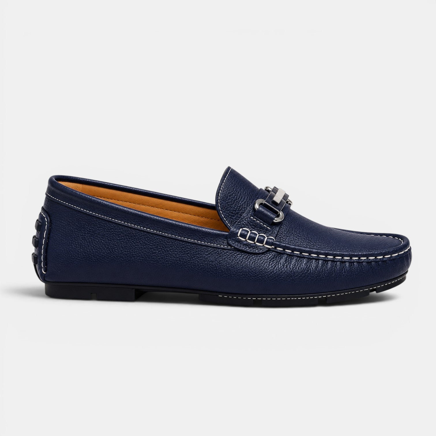 Navy blue loafer shoe with a silver buckle on a light gray background