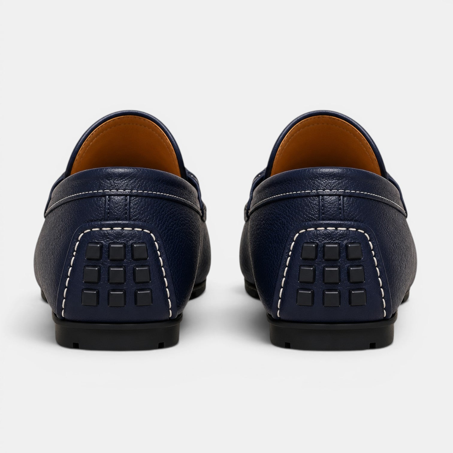 Pair of navy blue leather loafers on a white background