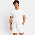 Man wearing a white t-shirt and shorts on a plain background