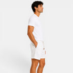 Man wearing a white t-shirt and shorts on a light gray background