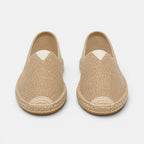 Pair of beige espadrilles on a light gray background
